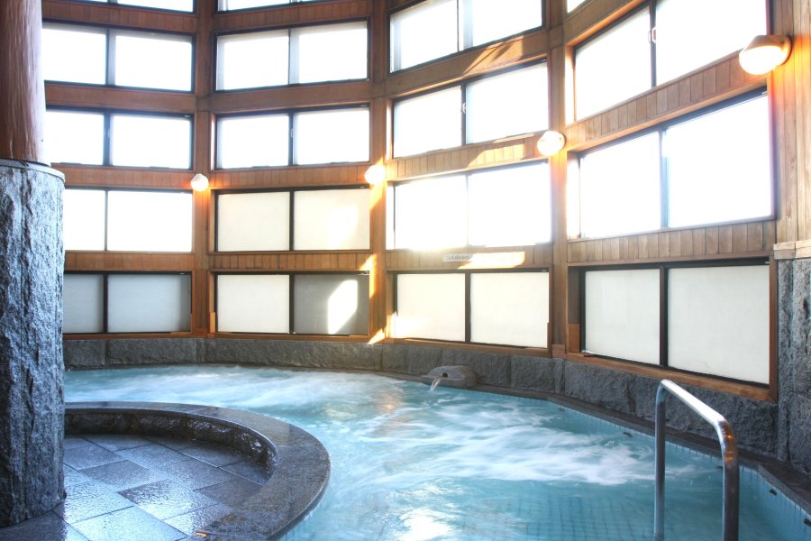 天井が高く窓が多い造りの浴室は、温かな光溢れる憩いの空間となっている。