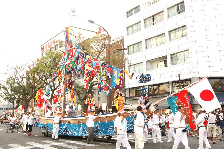 伝統を後世に受け継ぐ櫂伝馬「剣の舞」は、大漁旗を掲げ市内を練り歩く。剣の舞う姿は勇壮そのもの。