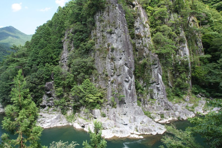川をせき止めるかのように切り立った戻ヶ嶽と呼ばれる岩。岩肌には松の木が生えている。