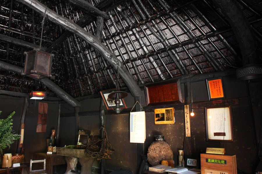 囲炉裏の香りが染みついた室内は、黒光りする天井や柱の照り艶、土壁の煤に年月の重みを感じる。