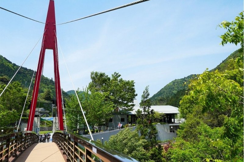 清流馬立川にかかる赤いトラス橋を渡るとカフェやレストラン、温泉など様々な施設がある。