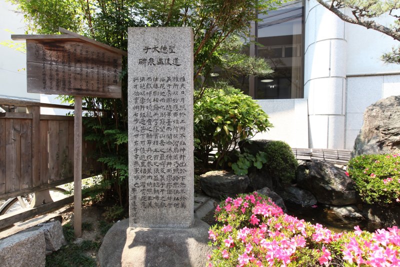 椿の湯の前に建つ碑文には、椿の名の由来となった伊予国風土記逸文に記されている聖徳太子が記したという文字が刻まれている。