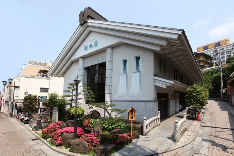 建物の壁面の「からくり絵」には、椿の湯の文字と窓から椿の花が温泉に流れ落ちる光景が描かれており、散策する人の目を楽しませてくれる。