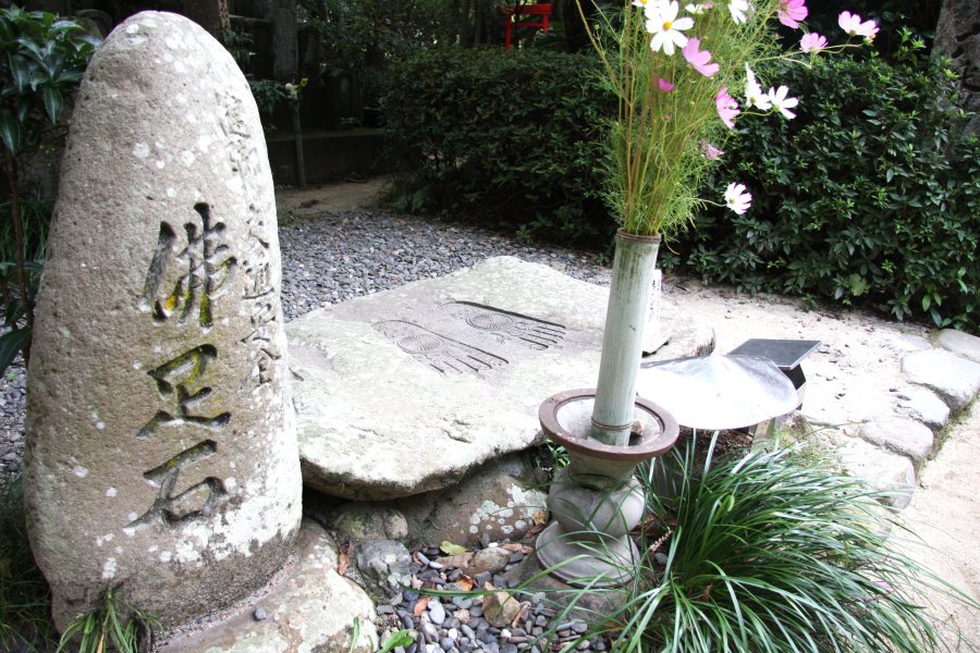 仏足石は、石に刻まれた仏の足跡に自らの足を重ね、健脚と交通安全を祈って踏拝する。