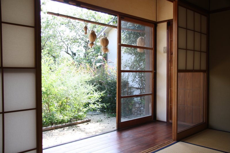 庭の風景を望みながらのんびりと過ごせる縁側。干し柿とすすきで作られたフクロウが吊るされ、どこか懐かしい雰囲気が漂う。