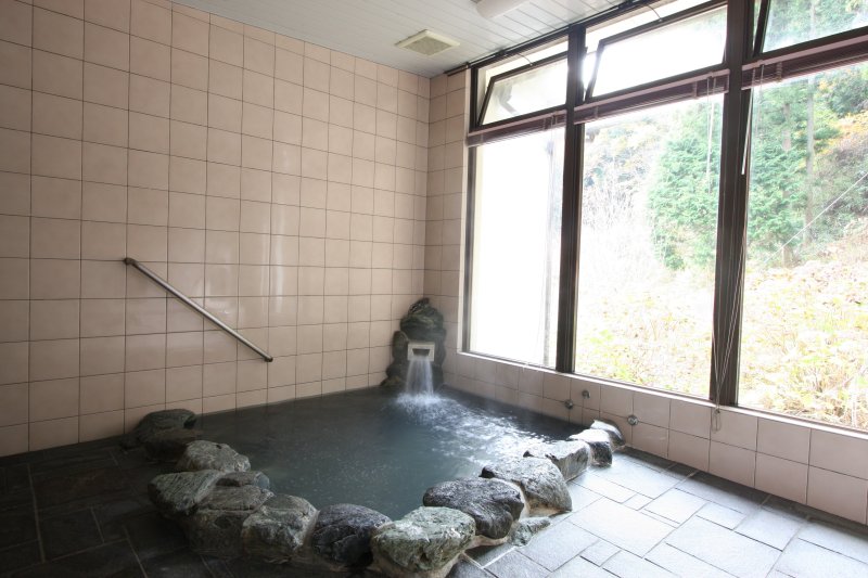 すぐ近くの源泉から潤沢に湧き出る良質な湯と、四季の移ろいを同時に堪能できる岩風呂の浴場。