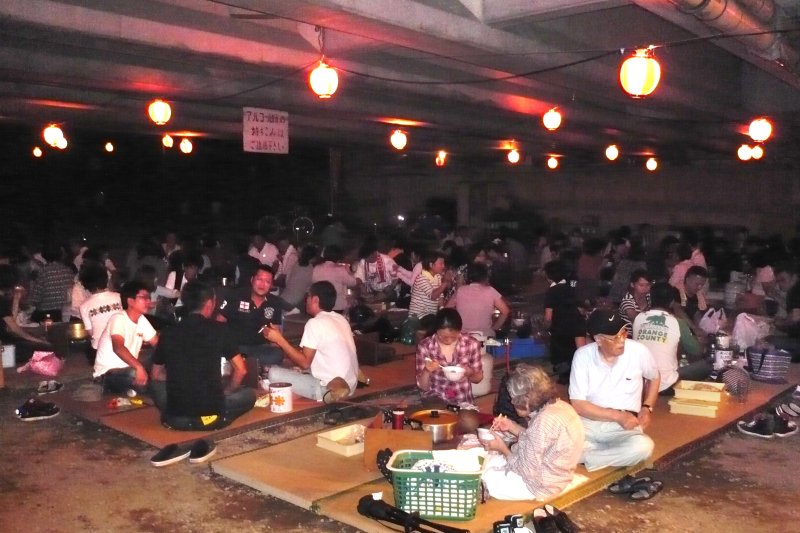 中山川に架かる橋の下に畳を敷いた会場は雨が降っても安心。