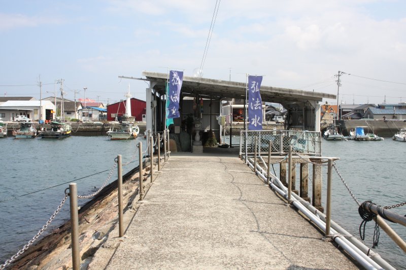 海底の水源から清水を汲み上げているため、波止の端に建てられている弘法水。水を汲む人々だけでなく、手を清める場として利用する地元住民も多い。