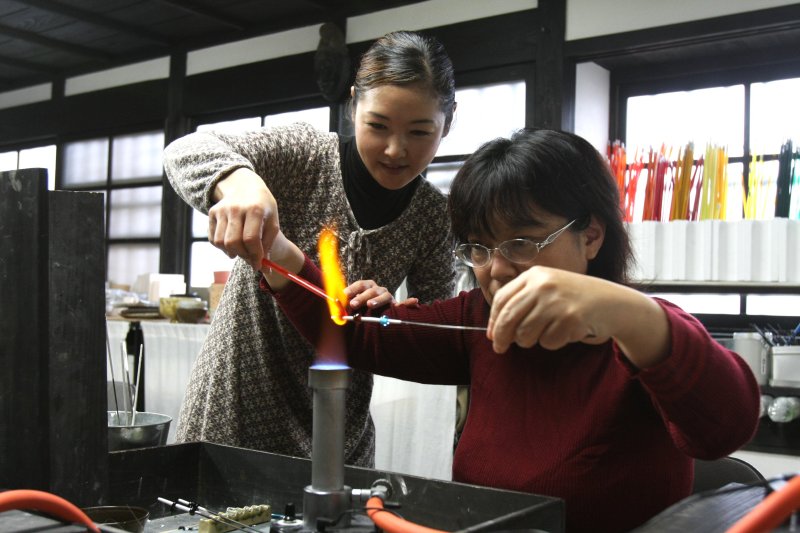 とんぼ玉教室は、バーナーであぶったガラスをくるくると棒に巻きつけていく緊張の作業。