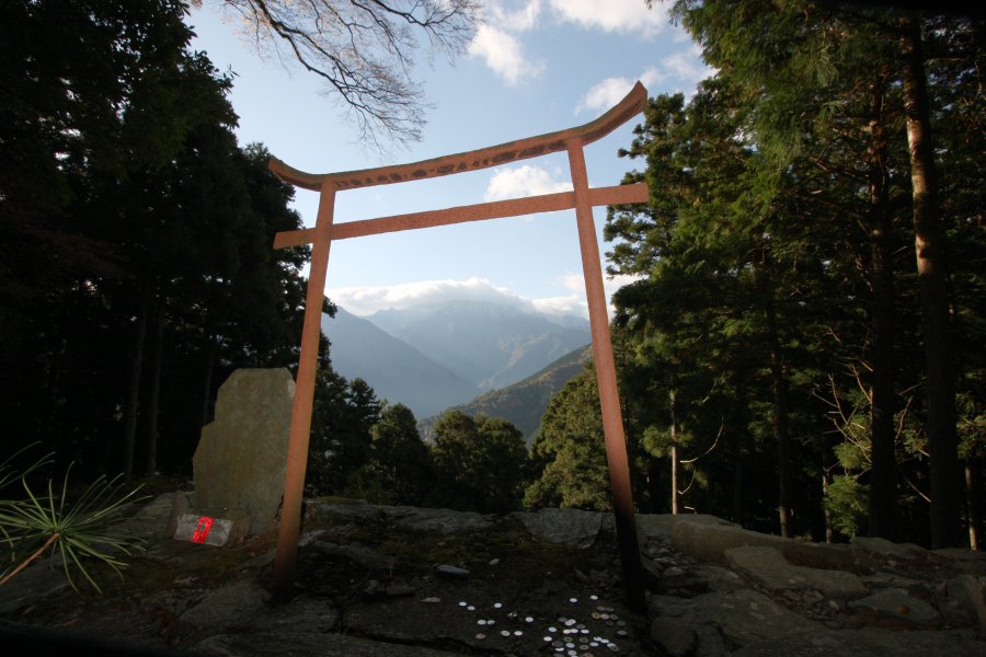 横峰寺山門の左方向には、石鎚山の西の遥拝所「星ヶ森」があり、 「かねの鳥居」越しの石槌山を望むことができる。