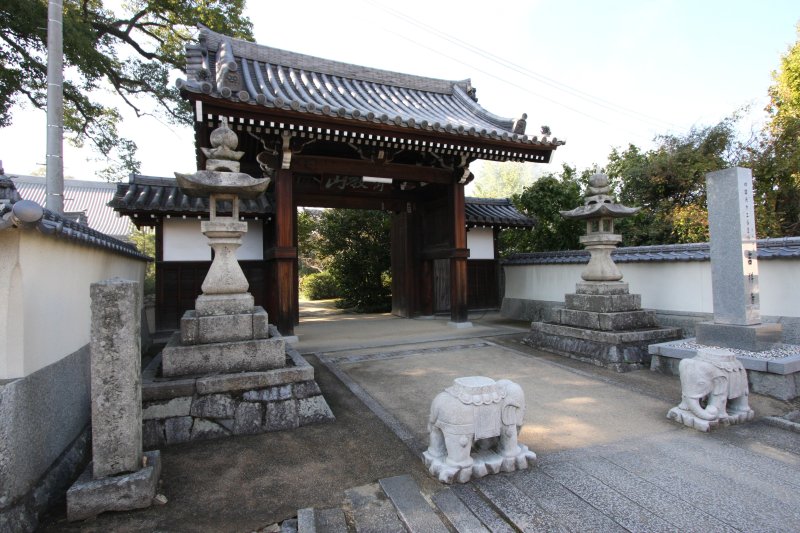 門前の小川に架かる石橋を渡り、山門をくぐると静かな境内が広がる。正面には本堂、左手には大師堂が建つ。 