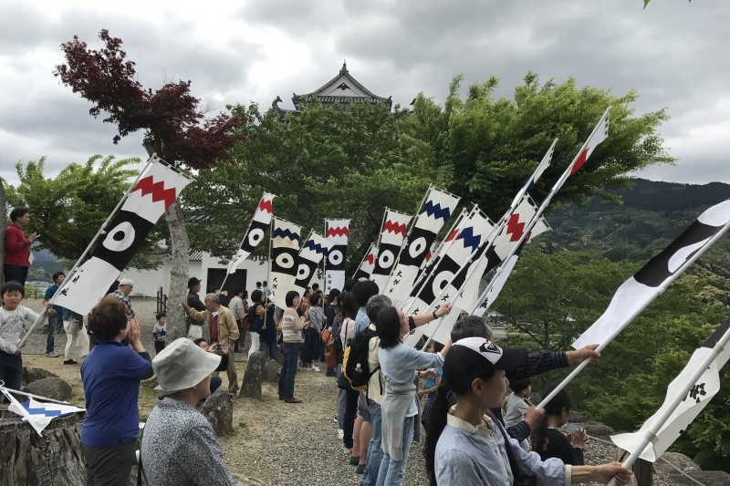 大洲城歓迎はたふりの写真。JR四国の観光列車「伊予灘ものがたり」が鉄橋をゆっくり渡るとき、大洲城本丸からのぼり旗を振って、歓迎しています。http://www.ozucastle.jp/hatafuri.html