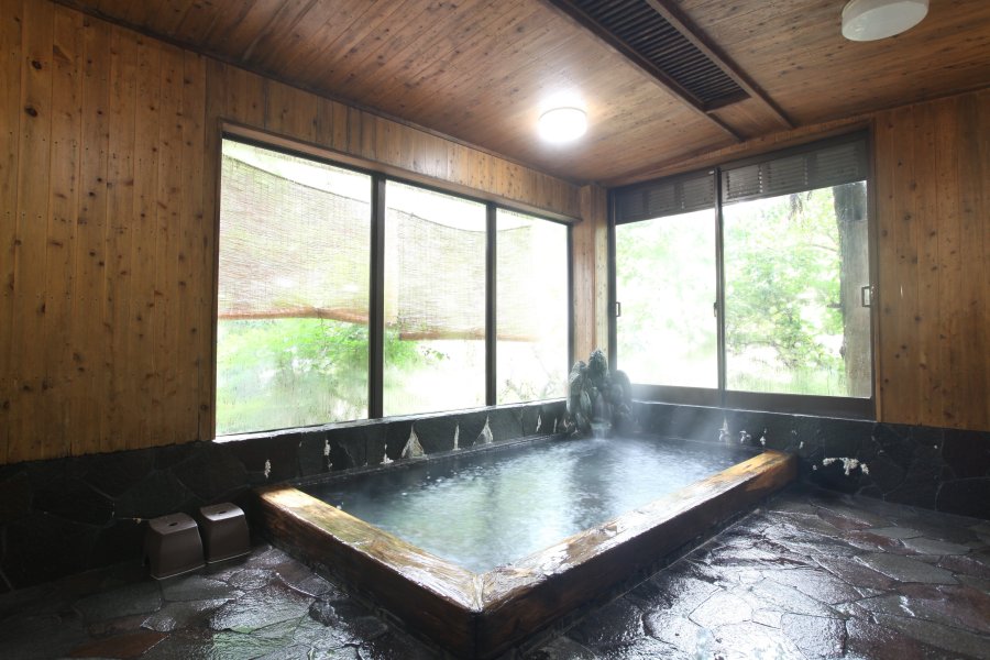 大浴場は桧風呂（男湯）と岩風呂（女湯）があり、 大きな窓からは裏手を流れる小薮川や四季折々の自然を楽しむことができる。