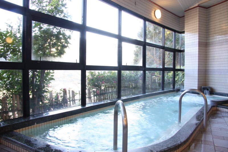 一面がガラス張りになった大浴場では、湯船に浸かりながら豊かな自然の景色を堪能できる。
