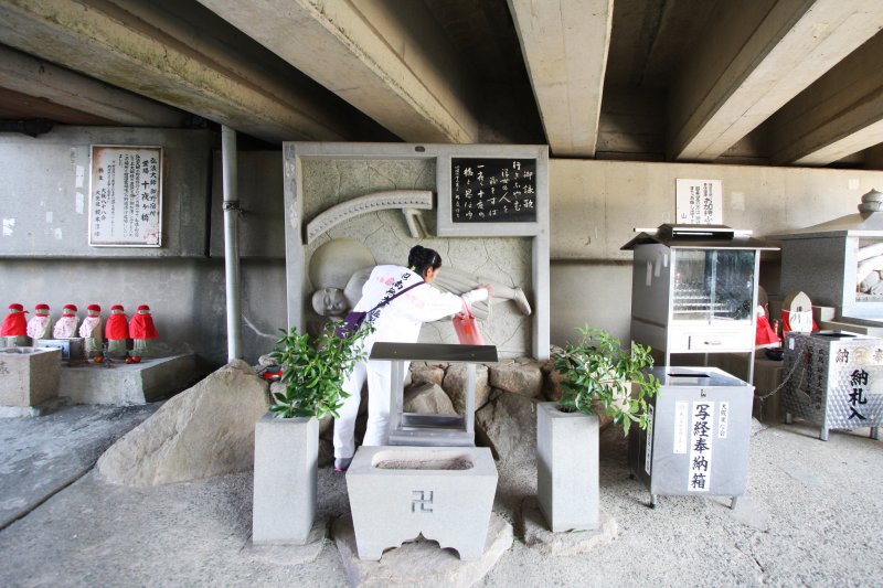 頭を撫でると願いが叶い、足を撫でると病気が治ると言われている大師の野宿像。
