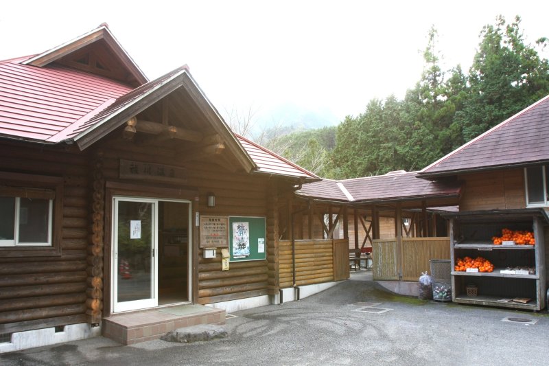 のどかな山間に赤い屋根がアクセントになっている、ログハウス調のかわいい外観。