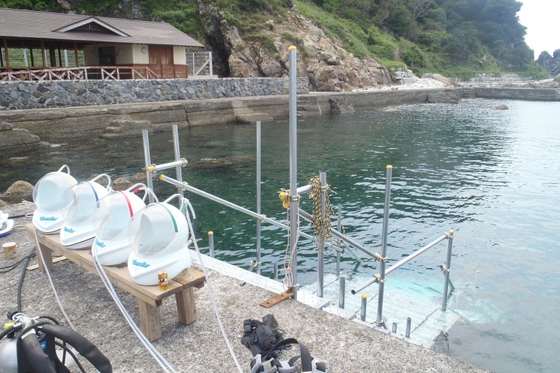 コップを逆さにして水につける原理のヘルメットには、地上とつながるホースで新鮮な空気を送らている。