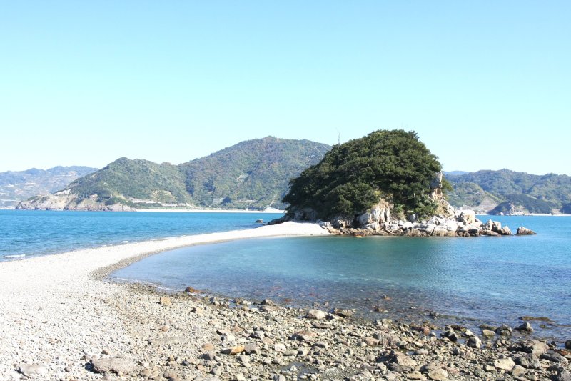 普段は離島だが、引き潮になると地大島から道が現れて渡れるようになる貝付小島。島の裏側には白亜の灯台が建ち、西予市の諏訪崎から眺めることができる。
