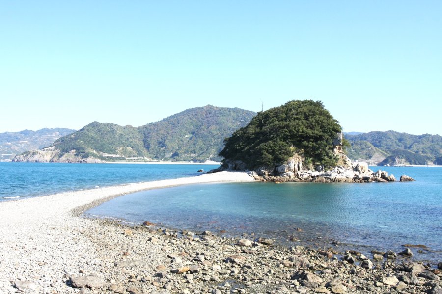 普段は離島だが、引き潮になると地大島から道が現れて渡れるようになる貝付小島。島の裏側には白亜の灯台が建ち、西予市の諏訪崎から眺めることができる。