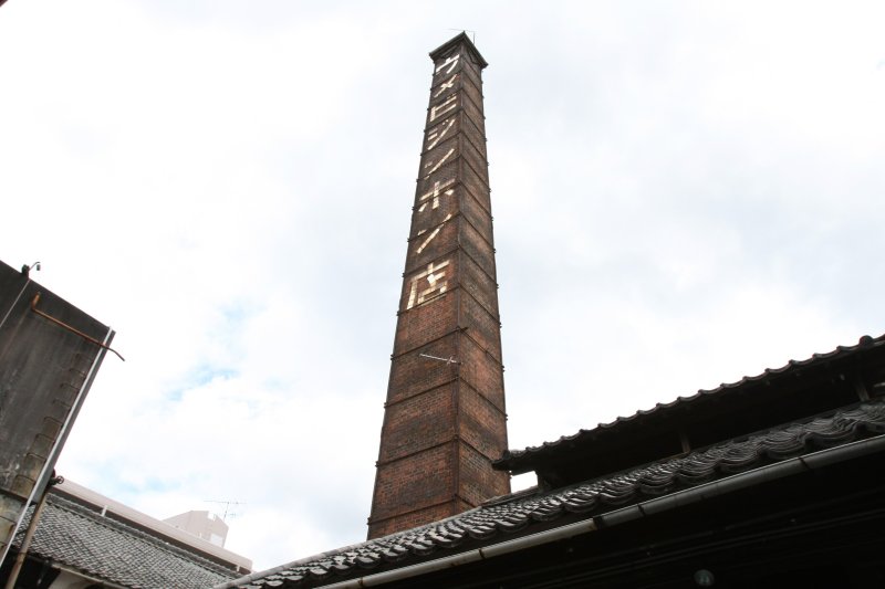 昭和3年に建設された「ウメビジンホン店」と白タイルで描かれたレンガ煙突。かつては港からも見えていたこの煙突は地域のランドマーク的存在だった。
