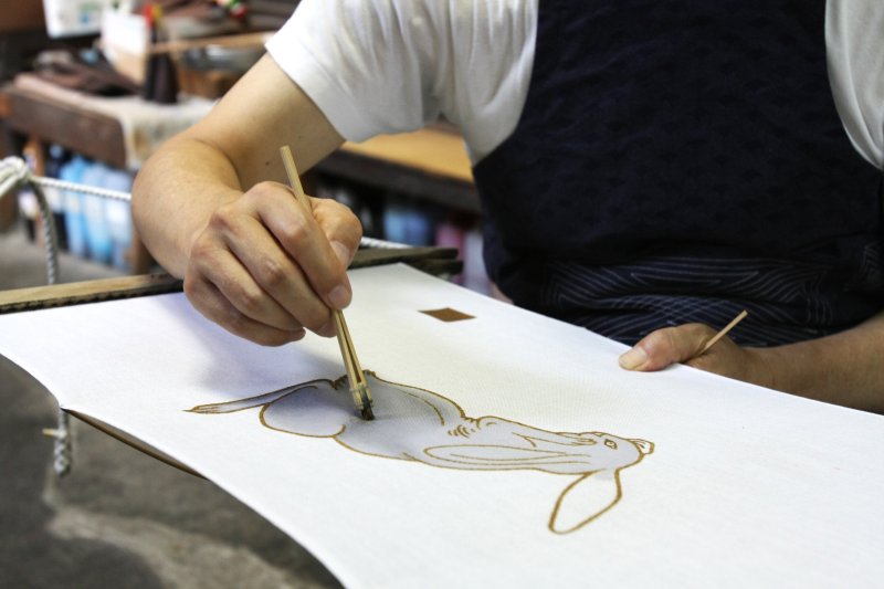 「筒描き染め」という伝統技法により一点一点手作業で染められる。