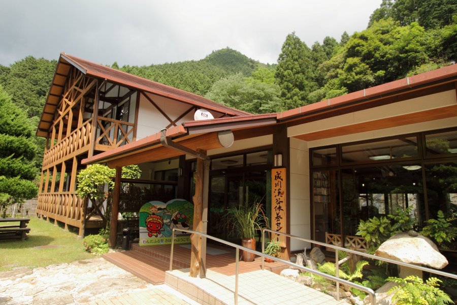 緑豊かな大自然を背景に旅行気分を盛り上げてくれる外観の成川渓谷休養センター。