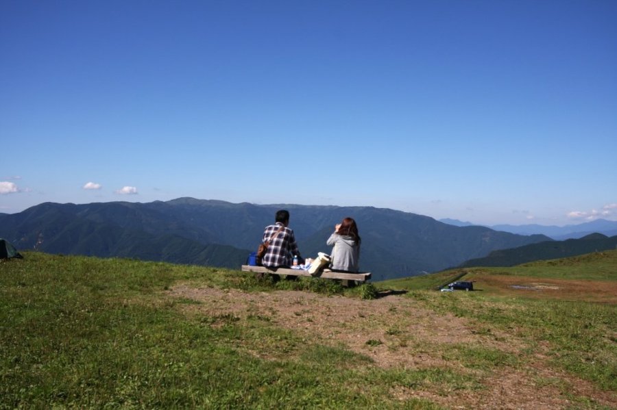 目の前に山々の稜線がパノラマで広がる広場では、休憩ができる東屋やベンチも設置されている。