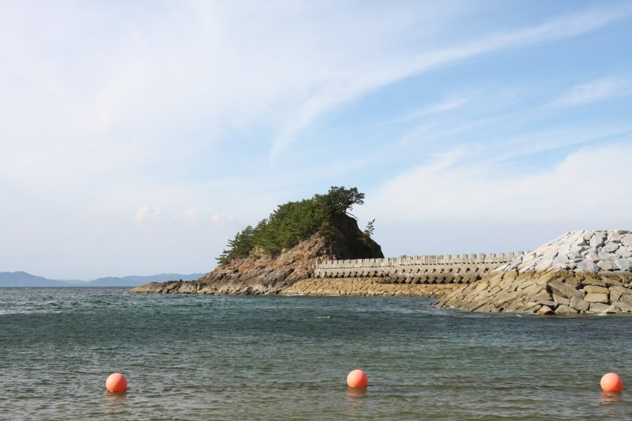 昭和54年に完成した消波堤により、徒歩で渡ることができるようになった小島は絶好の磯釣りポイント。