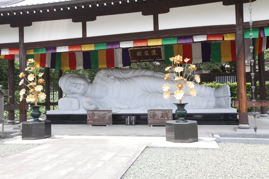 石造涅槃仏としては日本で最大級の長さ10m高さ3m、重さ200tの白御影石で造られた石仏が境内に安置されている。
