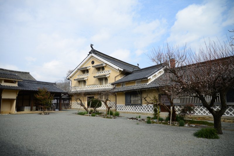 重厚な漆喰の壁と松の巨木をふんだんに使用した名家らしい風格が漂う建物。