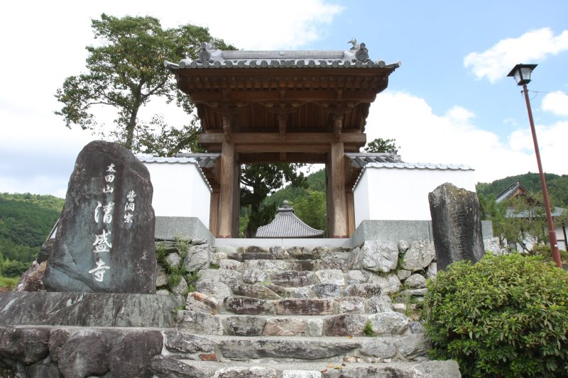 山門の横には白壁の塀が美しく続き、厳かな雰囲気に包まれた風格ある佇まい。