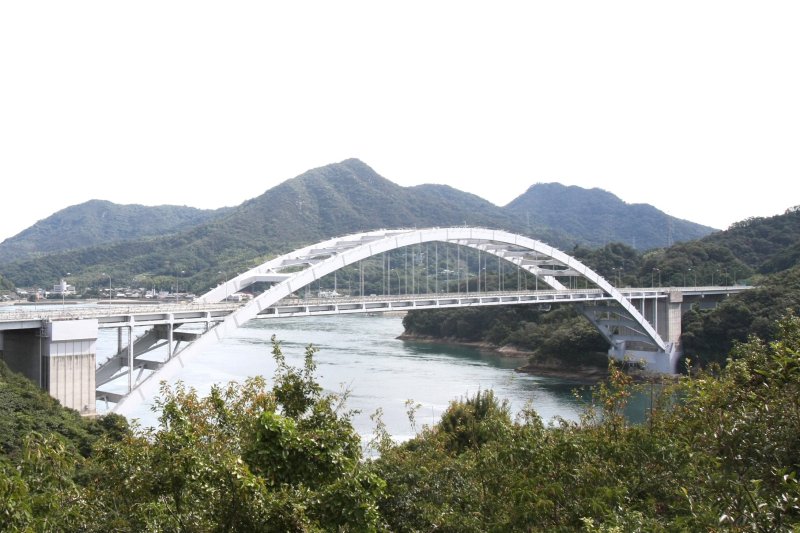 美しい弧を描く大三島橋の白と島々の緑、そして青く広がる空と海のコントラストが素晴らしい眺め。