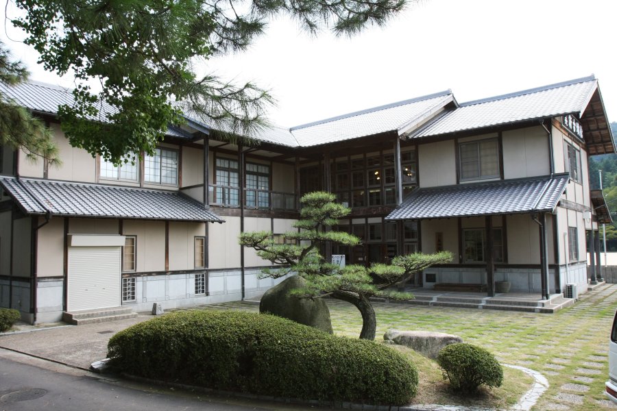 美しく整備された庭の中に建つ古風な日本建築風の外観。